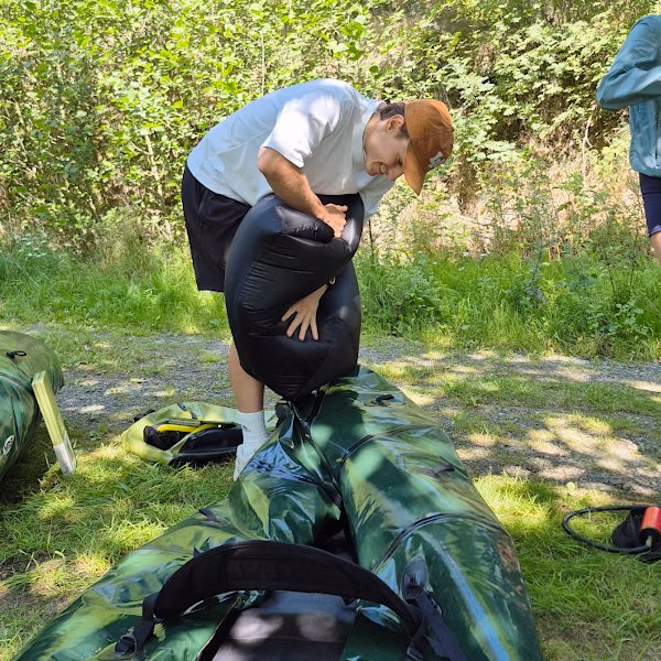 Dieser junge Mann befüllt das Packraft mit Luft