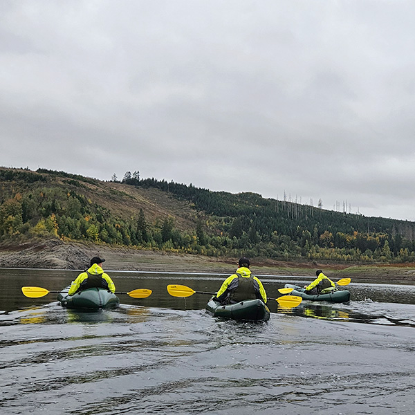 Diese Männer halten beim JGA inne und genießen den Moment auf dem Wasser