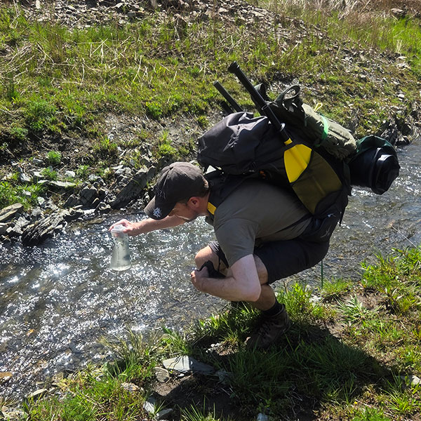 Ein Mann Filtern Wasser im Fluss